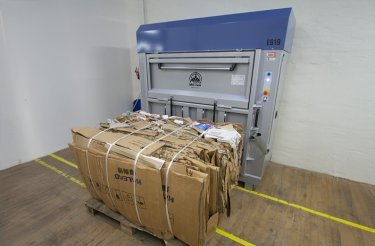 elektrisk balpress och en kartongbal framför