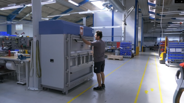 mörkhårig man som använder en stor balpress