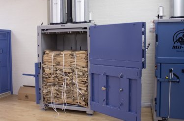 balpress med en kartongbal i