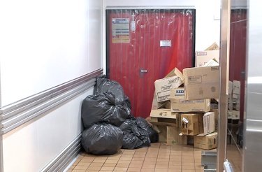 Röd dörr blockerad av kartong och soppåsar