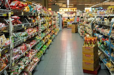 gång i butik med fyllda hyllor på båda sidor